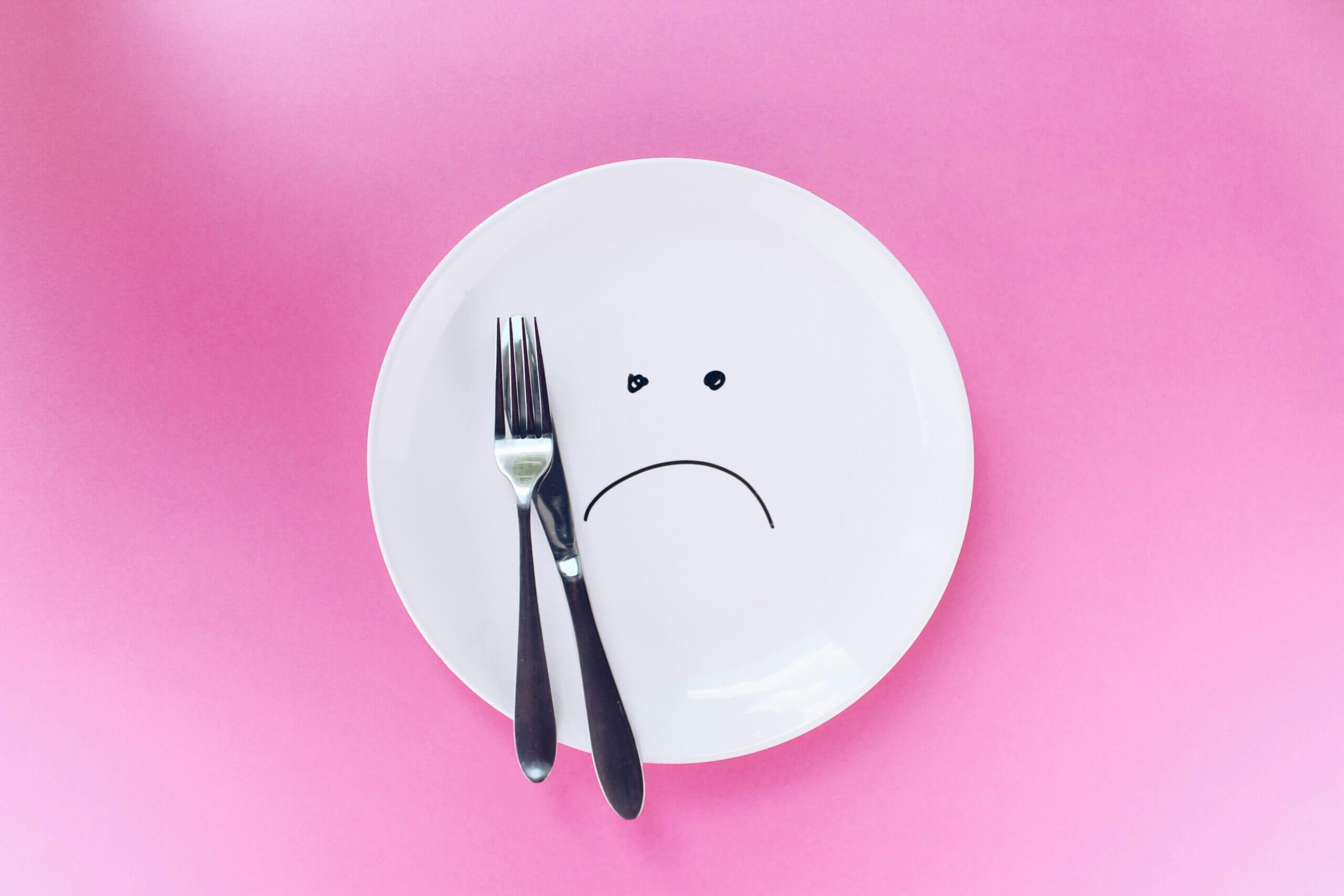 A plate with a frown, along with a fork and knife